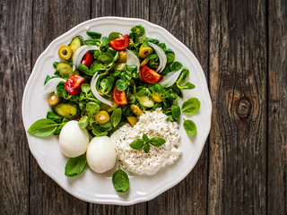 Delicious breakfast - boiled eggs with cottage cheese and vegetables served on wooden table
