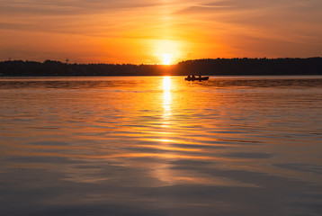 Fototapeta na wymiar Boat at sunset on Lake Senezh in the city of Solnechnogorsk