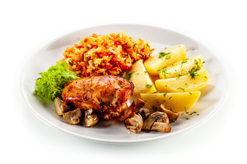 Fried chicken breast with boiled potatoes and vegetables on white background
