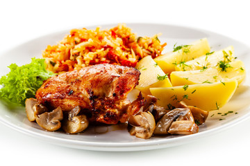 Fried chicken breast with boiled potatoes and vegetables on white background
