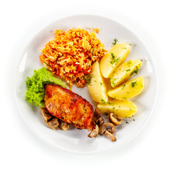 Fried chicken breast with boiled potatoes and vegetables on white background
