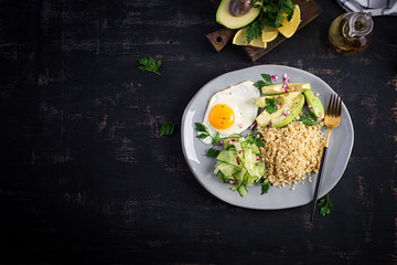 Diet menu. Healthy lifestyle. Bulgur porridge, fried egg and fresh vegetables -  cucumber and avocado on plate. Top view, overhead, copy space