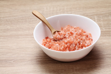 Fototapeta na wymiar Himalayan pink salt in ceramic cup on wooden table