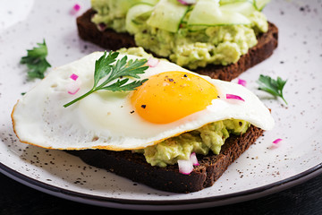 Healthy breakfast. Sandwich with avocado guacamole, cucumber and fried egg,   for healthy breakfast or snack.