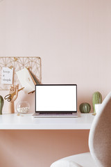 Laptop with blank white screen on office desk interior. Stylish gold workplace mockup table view.