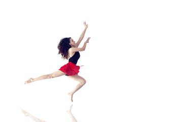 A long-legged girl jumping in front of a minimalist, graceful background