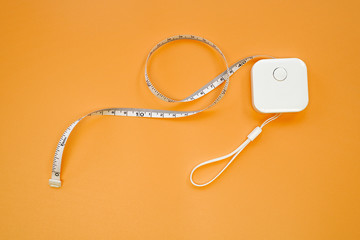 Small or mini portable White measure tape isolated on orange background