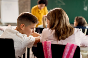Elementary classmates talking during a class at the school.