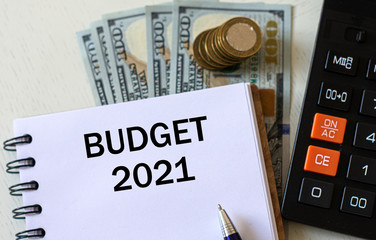 BUDGET 2021 word in a notebook against the background of calculitar and banknotes