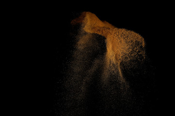 Sandy explosion isolated on black background. Abstract sand cloud.