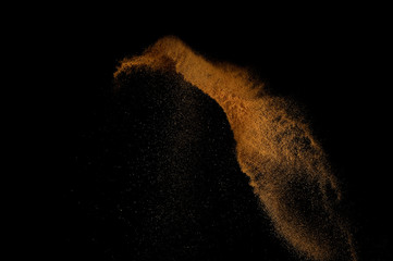 Sandy explosion isolated on black background. Abstract sand cloud.