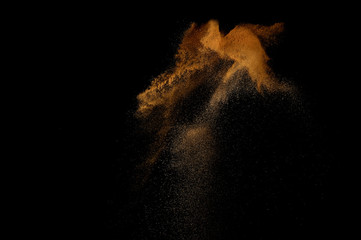 Sandy explosion isolated on black background. Abstract sand cloud.