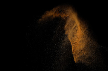 Fototapeta na wymiar Sandy explosion isolated on black background. Abstract sand cloud.