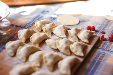 Dumplings with raspberries on the kitchen table.