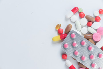 close up of colorful pills spilling from container 