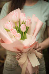 Obraz na płótnie Canvas Woman holding pink tulip flower bouquet using as background wedding flower shop