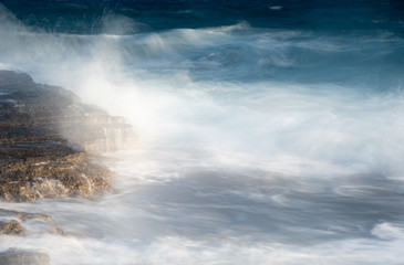 Splashing stormy windy sea waves on a rocky seashore