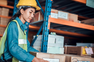 Confident Asian woman owner standing at goods warehouse store and check for control loading containers box from Cargo freight ship for import and export
