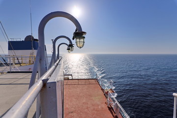 Ship structures, masts, antennas, funnel, ship wheelhouse against the blue sky and clouds. Vessel traveling at ocean. © masterskuz55