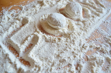 making homemade dumplings with your hands. The table is in flour.