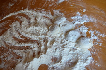 making homemade dumplings with your hands. The table is in flour.