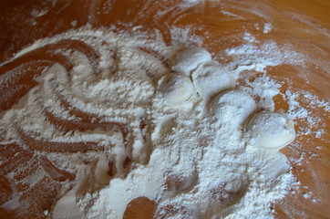 making homemade dumplings with your hands. The table is in flour.