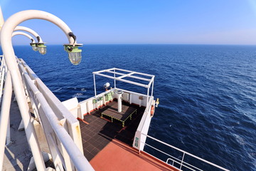 Ship structures, masts, antennas, funnel, ship wheelhouse against the blue sky and clouds. Vessel traveling at ocean. © masterskuz55