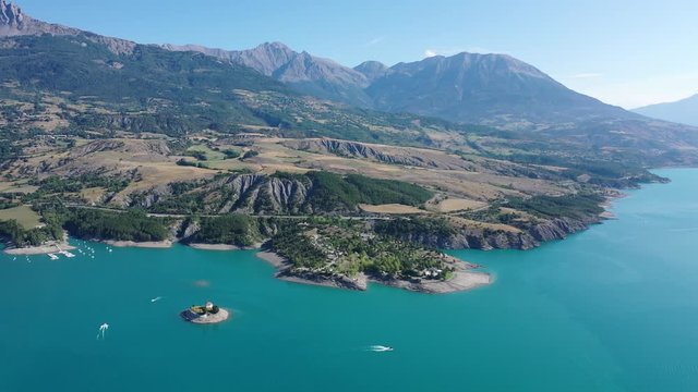 Scenic mountain landscape of French Alps with turquoise waterspace of artificial Lake Serre-Poncon in sunny summer day, France