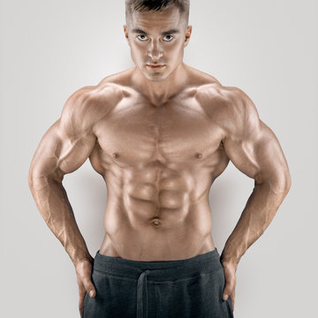 Sexy and young power athletic man with great physique. Perfect fit, six pack, abs, shoulders, deltoids, biceps, triceps and chest.