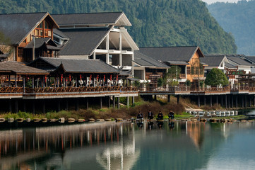 The sunrise scenery of Xibu Street in Zhangjiajie, Hunan province is composed of stilted buildings, ancient buildings, streets, rivers, orange sky and reflection as the background, and quiet effect. C
