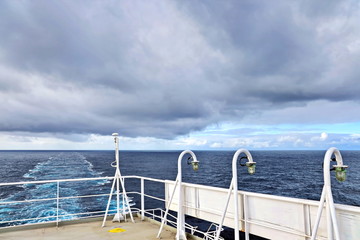 Ship structures, masts, antennas, funnel, ship wheelhouse against the blue sky and clouds. Vessel traveling at ocean. © masterskuz55