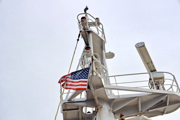 Ship structures, masts, antennas, funnel, ship wheelhouse against the blue sky and clouds. Vessel traveling at ocean. © masterskuz55