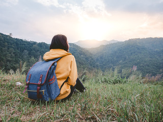 woman hiking with backpack relaxing in nature and enjoy the sunset view on mountain peak at Mae Wong national park Thailand.