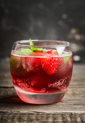Raspberry and mint cocktail in glass on the rustic background. Selective focus. Shallow depth of field.