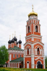 Fototapeta na wymiar red and white orthodox church on a cloudy summer day