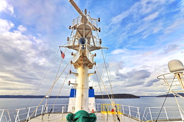 Ship structures, masts, antennas, funnel, ship wheelhouse against the blue sky and clouds. Vessel traveling at ocean. © masterskuz55