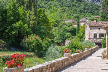 Rue Fleurie d'un village provençal du sud de la France. Village de Saint Guilhem le désert, étape de saint Jacques de Compostelle, Occitanie, France.