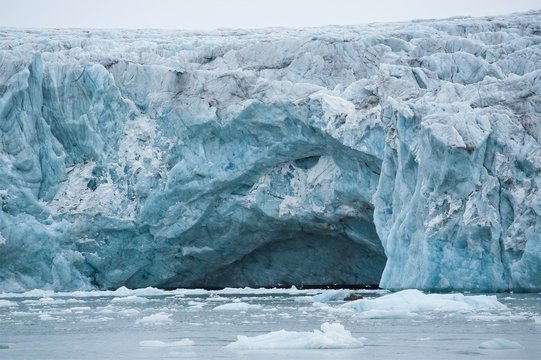 Gletscherh&ouml;hle mit farbig blauem Eis an der K&uuml;ste Spitzbergens - Impression einer Kreuzfahrt
