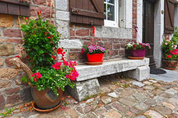 Fototapeta na wymiar Picturesque setting of a stone bench in front of an old house 
