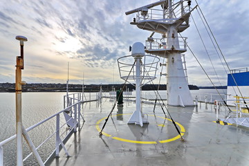 Ship structures, masts, antennas, funnel, ship wheelhouse against the blue sky and clouds. Vessel traveling at ocean. © masterskuz55