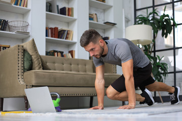 Handsome man doing sport exercise at home. Concept of healthy life.