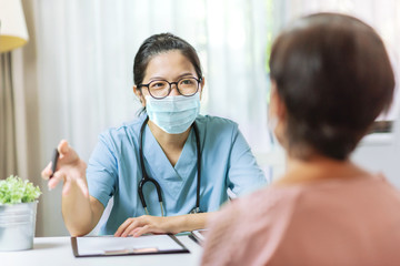 Asian Woman Doctor talking to female patient at the hospital