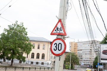 Traffic signs on the pole. For speed limit and attention to children. In Romania