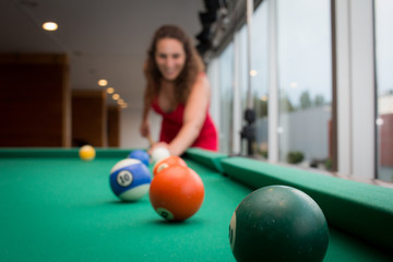 woman playing pool and smiling