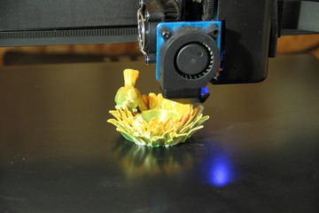a 3d printer while printing a flower with a bird