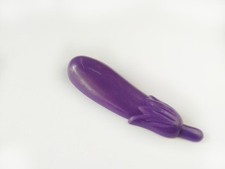 Purple eggplant toy made from plastic on white background, usually used by children to play