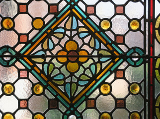 multicolored stained glass window with a flower pattern in a square