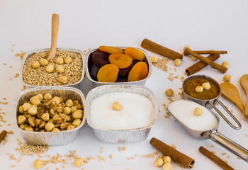 Uncooked ingredients of Traditional Dessert Asure,Noah Puding in aluminum bowls,foil containers -take away package-on the white surface