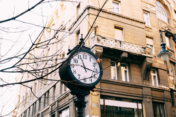 Fototapeta na wymiar An old street post with a clock, on the streets of Budapest.