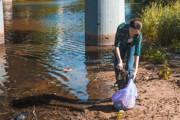 Cleaning up garbage, volunteer work. Caring for nature. People left a lot of plastic garbage on the...